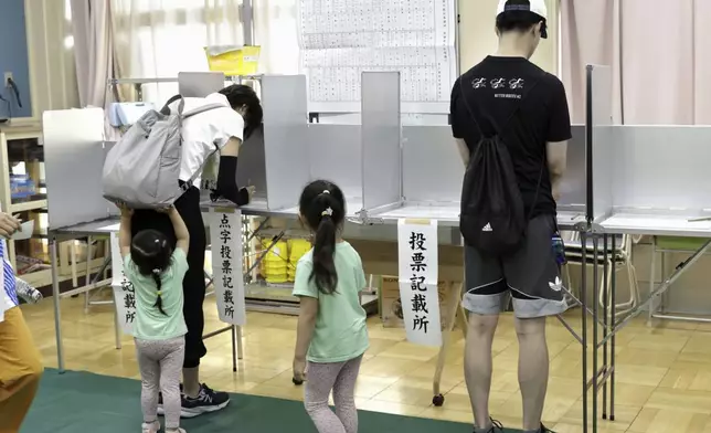 Voters fill out their paper ballots at a polling station in Tokyo Sunday, July 7, 2024. Voters in Tokyo are casting their ballots Sunday in gubernatorial election. (Kyodo News via AP)