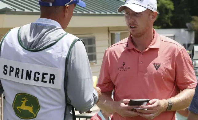 First-round leader Hayden Springer, right, talks with his caddie Michael Burns prior to second-round play at the John Deere Classic golf tournament Friday, July 5, 2024, at TPC Deere Run in Silvis, Ill. (Roy Dabner/Quad City Times via AP)