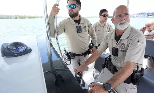 Officers with the Miami-Dade County Police Department's Marine Patrol, Adam Fullana, left, Sean Carper, center, and Thomas Kennedy, right, are shown, Wednesday, July 3, 2024, near Key Biscayne, Fla. Elected officials and law enforcement agencies urged boaters not to drink and drive, check the weather before going out and to consider taking a boater safety course during a news conference ahead of the holiday weekend. (AP Photo/Wilfredo Lee)