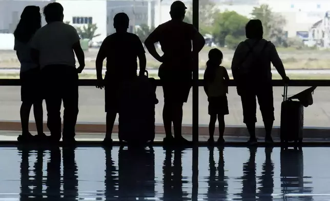 Holiday travelers pass through Salt Lake City International Airport Wednesday, July 3, 2024, in Salt Lake City. (AP Photo/Rick Bowmer)