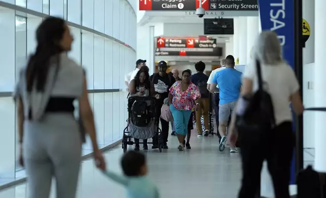 Travelers walk through the Philadelphia International Airport, Wednesday, July 3, 2024, in Philadelphia. (AP Photo/Matt Slocum)