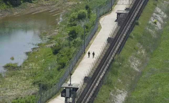 FILE - South Korean army soldiers patrol along the barbed-wire fence in Paju, South Korea, near the border with North Korea, Friday, May 31, 2024. South Korea said Friday, July 19, 2024, it has restarted anti-Pyongyang propaganda broadcasts across the border in response to North Korea’s resumption of trash-carrying balloon launches. (AP Photo/Ahn Young-joon, File)