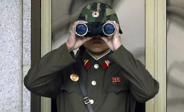 FILE - In this Tuesday, April 23, 2013, file photo, a North Korean soldier looks at the southern side through a pair of binoculars at the border village of Panmunjom, which has separated the two Koreas since the Korean War, in Paju, north of Seoul, South Korea. South Korea said Friday, July 19, 2024, it has restarted anti-Pyongyang propaganda broadcasts across the border in response to North Korea’s resumption of trash-carrying balloon launches. (AP Photo/Lee Jin-man, File)