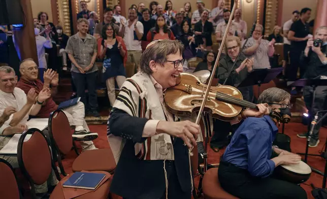 Rabbi Sharon Kleinbaum plays the violin during her last service at the Masonic Hall, Friday, June 28, 2024, in New York. After leading the nation’s largest LGBTQ+ synagogue through the myriad ups and downs of the modern gay-rights movement for the last three decades, she is now stepping down from that role and shifting into retirement. The synagogue that she led for 32 years — Congregation Beit Simchat Torah in midtown Manhattan — will have to grapple with its identity after being defined by its celebrity rabbi for so long. (AP Photo/Andres Kudacki)