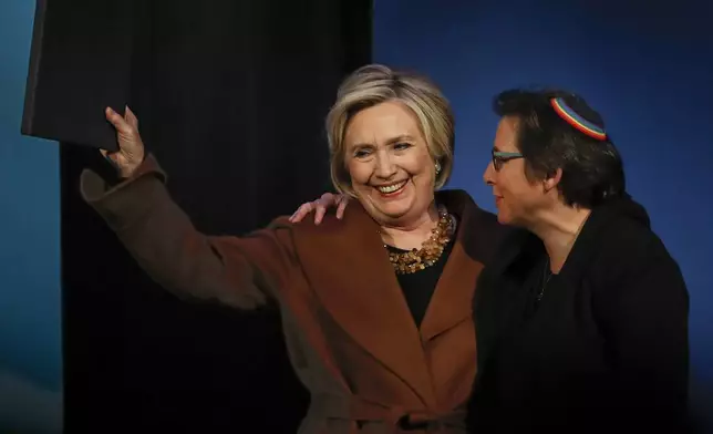 FILE - Former Secretary of State Hillary Clinton, left, waves to the crowd after speaking during a benefit to celebrate the 25th anniversary of Rabbi Sharon Kleinbaum, right, at Congregation Beit Simchat Torah, Dec. 4, 2017, in New York. After 32 years as a progressive voice for LGBTQ Jews, and leader of Congregation Beit Simchat Torah in midtown Manhattan, Kleinbaum steps into retirement. (AP Photo/Julie Jacobson)