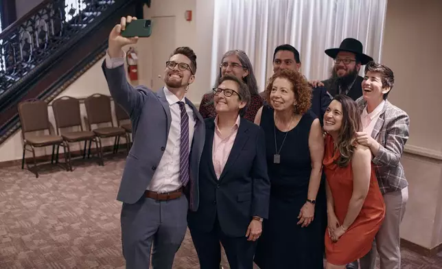 Rabbi Sharon Kleinbaum, second from left, takes a selfie with members of her congregation as she prepares for her last service at the Masonic Hall, on Friday, June 28, 2024, in New York. (AP Photo/ Andres Kudacki)