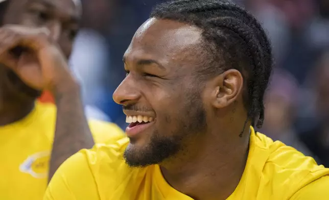 Los Angeles Lakers guard Bronny James laughs with teammates while sitting on the bench during the second half of an NBA summer league basketball game against the Golden State Warriors in San Francisco, Sunday, July 7, 2024. (AP Photo/Nic Coury)