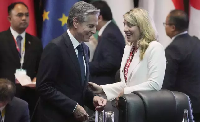 U.S. Secretary of State Antony Blinken, left, and Canada's Foreign Minister Melanie Joy, right, talk before the ASEAN Regional Forum Ministerial Meeting in Vientiane, Laos, Saturday, July 27, 2024. (AP Photo/Achmad Ibrahim, Pool)