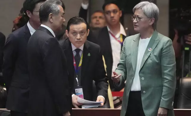 Chinese Foreign Minister Wang Yi, left, talks with Australian Minister of Foreign Affairs Penny Wong, right, during the East Asia Summit Foreign Ministers' Meeting in Vientiane, Laos, Saturday, July 27, 2024. (AP Photo/Achmad Ibrahim, Pool)