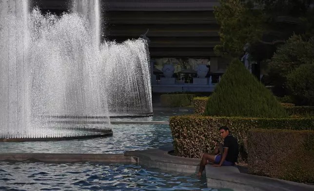 A person cools off in a fountain at Caesars Palace along the Las Vegas Strip, Sunday, July 7, 2024, in Las Vegas. The city set an all time record high of 120 F (48.8 C) Sunday as a heat wave spread across the Western U.S. sending many residents in search of a cool haven from the dangerously high temperatures. (AP Photo/John Locher)