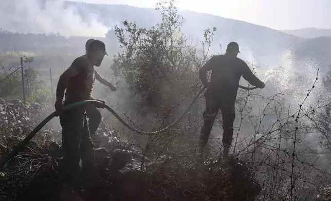 Lebanese Civil Defence firefighters extinguish fires that erupted by Israeli shelling at a cherry orchard in Chebaa, a Lebanese town near the border with Israel, south Lebanon, Friday, June 14, 2024. AP Photo/Ramiz Dallah)