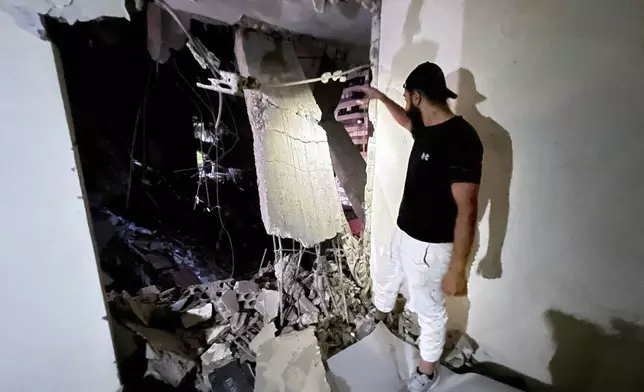 A man inspects a destroyed building that was hit by an Israeli airstrike in the southern suburbs of Beirut, Lebanon, Tuesday, July 30, 2024. An Israeli airstrike hit Hezbollah's stronghold south of Beirut Tuesday evening causing damage, a Hezbollah official and the group's TV station said. (AP Photo/Hussein Malla)