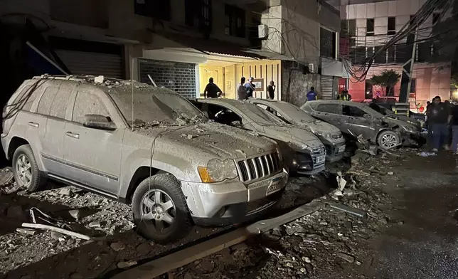 People inspect damaged cars in the southern suburbs of Beirut, Lebanon, Tuesday, July 30, 2024. An Israeli airstrike hit Hezbollah's stronghold south of Beirut Tuesday evening causing damage, a Hezbollah official and the group's TV station said. (AP Photo/Hussein Malla)