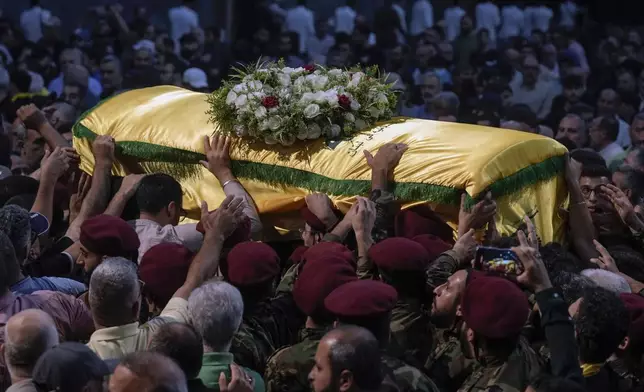 Hezbollah fighters carry the coffin of their comrade, senior commander Mohammad Naameh Nasser, who was killed by an Israeli airstrike that hit his car in the southern costal town of Tyre, during his funeral procession in the southern suburbs of Beirut, Lebanon, Thursday, July 4, 2024. (AP Photo/Bilal Hussein)