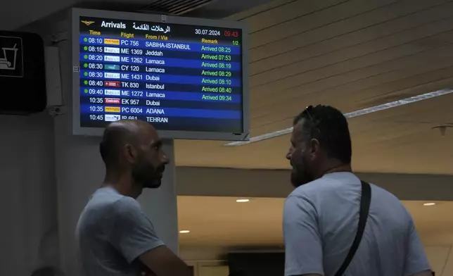 People wait at the arrival terminal of the Rafik Hariri International Airport in Beirut, Lebanon, Tuesday, July 30, 2024. Fears of an escalation in the simmering conflict between Hezbollah and Israel have prompted some airlines to cancel flights to Lebanon, but business appeared to be proceeding as usual Tuesday at the Beirut airport, where many travelers greeted the warnings with a shrug. (AP Photo/Hassan Ammar)