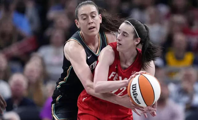 Indiana Fever's Caitlin Clark (22) makes a pass as New York Liberty's Breanna Stewart (30) defends during the first half of a WNBA basketball game, Saturday, July 6, 2024, in Indianapolis. (AP Photo/Darron Cummings)