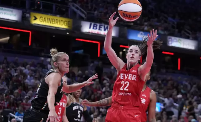 Indiana Fever's Caitlin Clark (22) grabs a rebound ahead of New York Liberty's Leonie Fiebich (13) during the first half of a WNBA basketball game, Saturday, July 6, 2024, in Indianapolis. (AP Photo/Darron Cummings)