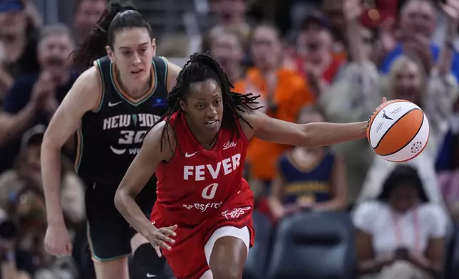 Indiana Fever's Kelsey Mitchell (0) makes a steal against New York Liberty's Breanna Stewart (30) during the second half of a WNBA basketball game, Saturday, July 6, 2024, in Indianapolis. (AP Photo/Darron Cummings)