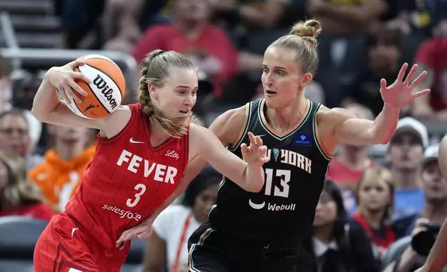 Indiana Fever's Kristy Wallace (3) goes to the basket against New York Liberty's Leonie Fiebich during the first half of a WNBA basketball game, Saturday, July 6, 2024, in Indianapolis. (AP Photo/Darron Cummings)