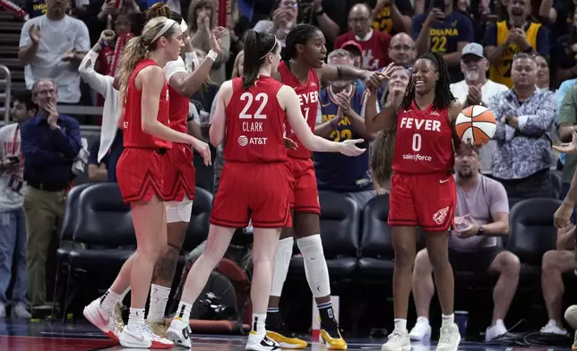 Indiana Fever's Kelsey Mitchell (0) smiles after getting a rebound during the second half of a WNBA basketball game against the New York Liberty, Saturday, July 6, 2024, in Indianapolis. (AP Photo/Darron Cummings)