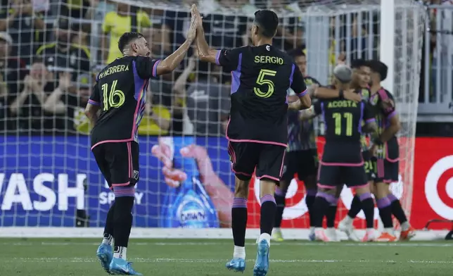 MLS All-Stars' Hector Herrera, left, and Sergio Busquets celebrate their goal against the Liga MX All-Stars during the first half of the MLS All-Star soccer match Wednesday, July 24, 2024, in Columbus, Ohio. (AP Photo/Jay LaPrete)