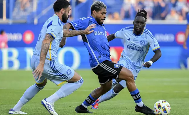 Atlanta United's Derrick Williams, left, and Tristan Muyumba (8) move in on CF Montreal's Josef Martínez, center, during the first half of an MLS soccer match in Montreal, Saturday, July 13, 2024. (Graham Hughes/The Canadian Press via AP)