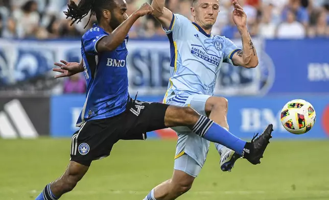 CF Montreal's Raheem Edwards, left, and Atlanta United's Bartosz Slisz, right, challenge for the ball during first-half MLS soccer match action in Montreal, Saturday, July 13, 2024. (Graham Hughes/The Canadian Press via AP)