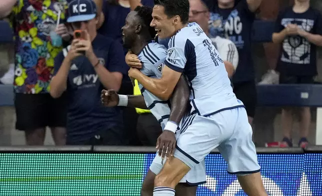 Sporting Kansas City attacker Willy Agada, left, celebrates with attacker Dániel Sallói after scoring a goal during the first half of an MLS soccer match against FC Dallas Sunday, July 7, 2024, in Kansas City, Kan. (AP Photo/Charlie Riedel)