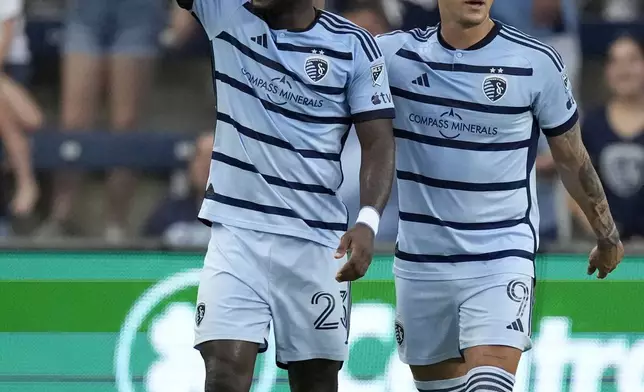 Sporting Kansas City attacker Willy Agada, left, celebrates with attacker Alán Pulido (9) after scoring a goal during the first half of an MLS soccer match against FC Dallas Sunday, July 7, 2024, in Kansas City, Kan. (AP Photo/Charlie Riedel)