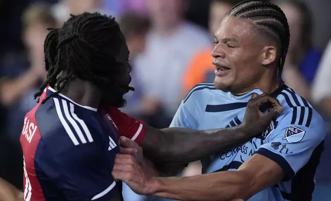 Sporting Kansas City defender Zorhan Bassong, right, and FC Dallas defender Ema Twumasi, left, scuffle during the second half of an MLS soccer match Sunday, July 7, 2024, in Kansas City, Kan. Sporting Kansas City won 3-2. (AP Photo/Charlie Riedel)