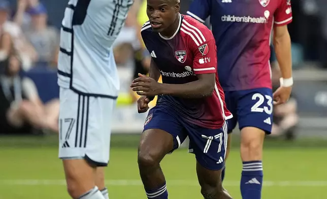 FC Dallas midfielder Bernard Kamungo (77) celebrates after scoring a goal during the first half of an MLS soccer match against Sporting Kansas City Sunday, July 7, 2024, in Kansas City, Kan. (AP Photo/Charlie Riedel)