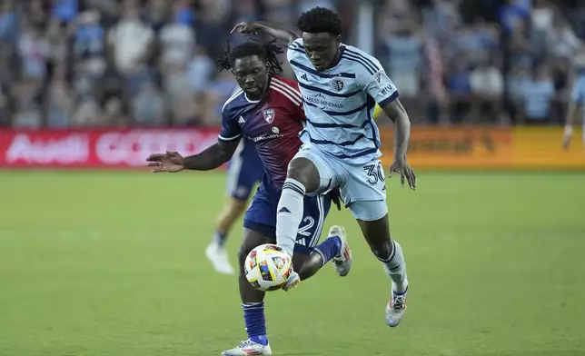 Sporting Kansas City attacker Stephen Afrifa (30) is chased by FC Dallas defender Ema Twumasi as he moves the ball during the second half of an MLS soccer match Sunday, July 7, 2024, in Kansas City, Kan. Sporting Kansas City won 3-2. (AP Photo/Charlie Riedel)