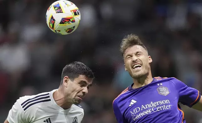 Vancouver Whitecaps' Brian White, left, and Houston Dynamo's Erik Sviatchenko vie for the ball during the second half of an MLS soccer match in Vancouver, British Columbia, Saturday, July 20, 2024. (Darryl Dyck/The Canadian Press via AP)