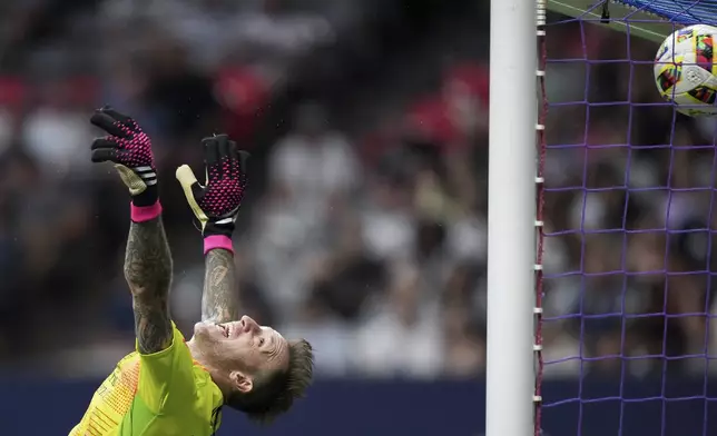 Houston Dynamo goalkeeper Steve Clark allows a goal to Vancouver Whitecaps' Ranko Veselinovic during the second half of an MLS soccer match in Vancouver, British Columbia, Saturday, July 20, 2024. (Darryl Dyck/The Canadian Press via AP)