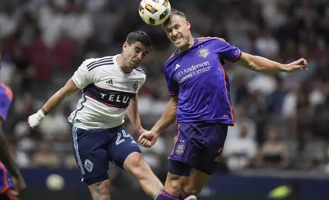 Vancouver Whitecaps' Brian White, left, and Houston Dynamo's Erik Sviatchenko vie for the ball during the second half of an MLS soccer match in Vancouver, British Columbia, Saturday, July 20, 2024. (Darryl Dyck/The Canadian Press via AP)