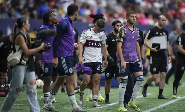 Vancouver Whitecaps' Ryan Gauld, center, who was substituted out of the match in the 30th minute, walks from the sideline during halftime of an MLS soccer match against against the Houston Dynamo in Vancouver, British Columbia, Saturday, July 20, 2024. (Darryl Dyck/The Canadian Press via AP)