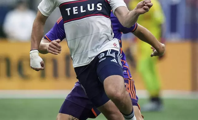 Vancouver Whitecaps' Brian White, front, and Houston Dynamo's Erik Sviatchenko, back, vie for the ball during the first half of an MLS soccer match in Vancouver, British Columbia, Saturday, July 20, 2024. (Darryl Dyck/The Canadian Press via AP)