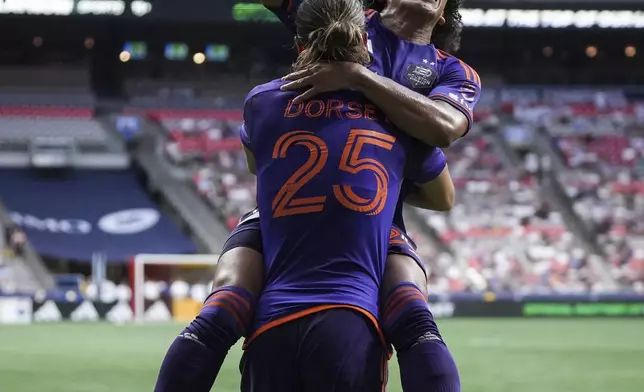 Houston Dynamo's Adalberto Carrasquilla, right, and Griffin Dorsey (25) celebrate after Carrasquilla's goal against the Vancouver Whitecaps during the first half of an MLS soccer match in Vancouver, British Columbia, Saturday, July 20, 2024. (Darryl Dyck/The Canadian Press via AP)