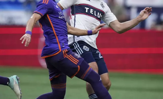 Vancouver Whitecaps' Brian White, right, and Houston Dynamo's Griffin Dorsey, left, vie for the ball during the first half of an MLS soccer match in Vancouver, British Columbia, Saturday, July 20, 2024. (Darryl Dyck/The Canadian Press via AP)