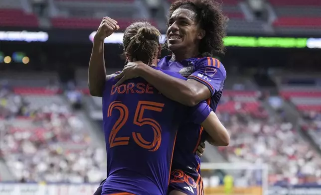 Houston Dynamo's Adalberto Carrasquilla, right, and Griffin Dorsey (25) celebrate Carrasquilla's goal against the Vancouver Whitecaps during the first half of an MLS soccer match in Vancouver, British Columbia, Saturday, July 20, 2024. (Darryl Dyck/The Canadian Press via AP)