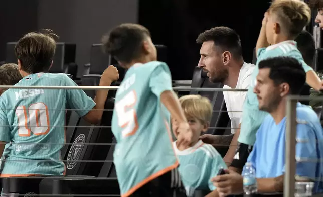 Inter Miami forward Lionel Messi, second from top right, watches from field-level seats during the second half of an MLS soccer match against the Chicago Fire Saturday, July 20, 2024, in Fort Lauderdale, Fla. Messi did not play due to an injury. (AP Photo/Lynne Sladky)