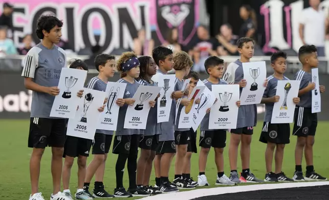 Children hold placards before a ceremony where Inter Miami forward Lionel Messi was honored for his 45 career trophies before an MLS soccer match against the Chicago Fire, Saturday, July 20, 2024, in Fort Lauderdale, Fla. (AP Photo/Lynne Sladky)