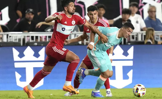 Chicago Fire defender Mauricio Pineda, left, defends against Inter Miami forward Luis Suárez, right, during the second half of an MLS soccer match, Saturday, July 20, 2024, in Fort Lauderdale, Fla. (AP Photo/Lynne Sladky)