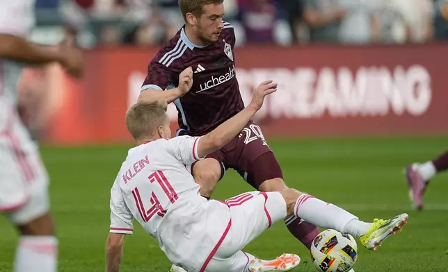 Colorado Rapids midfielder Connor Ronan, back, passes the ball as St. Louis City midfielder John Klein defends in the first half of a soccer match Sunday, July 7, 2024, in Commerce City, Colo. (AP Photo/David Zalubowski)