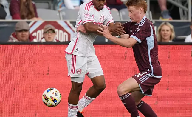 St. Louis City midfielder Njabulo Blom, left, passes the ball as Colorado Rapids midfielder Oliver Larraz defends in the first half of a MLS soccer match Sunday, July 7, 2024, in Commerce City, Colo. (AP Photo/David Zalubowski)