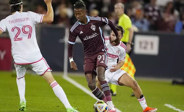 Colorado Rapids forward Kévin Cabral (91) drives between St. Louis City forward Nökkvi Þórisson (29) and midfielder Indiana Vassilev in the second half of a MLS soccer match Sunday, July 7, 2024, in Commerce City, Colo. (AP Photo/David Zalubowski)