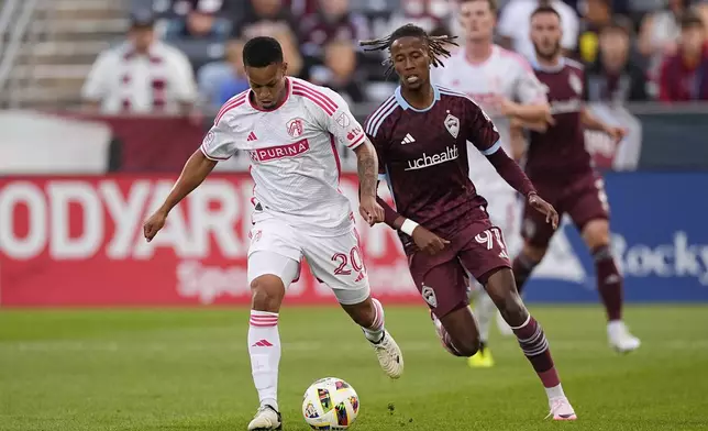 St. Louis City defender Akil Watts, left, passes the ball as Colorado Rapids forward Kévin Cabral defends in the first half of a MLS soccer match Sunday, July 7, 2024, in Commerce City, Colo. (AP Photo/David Zalubowski)