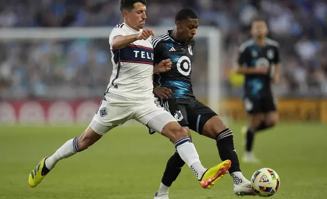 Vancouver Whitecaps midfielder Alessandro Schopf, left, and Minnesota United midfielder Joseph Rosales battle for possession of the ball during the second half of an MLS soccer match in St. Paul, Minn., Wednesday, July 3, 2024. (AP Photo/Abbie Parr)