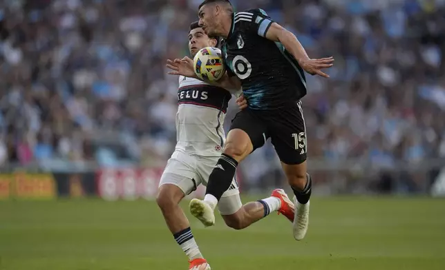 Vancouver Whitecaps forward Brian White, left, and Minnesota United defender Michael Boxall battle for possession of the ball during the first half of an MLS soccer match in St. Paul, Minn., Wednesday, July 3, 2024. (AP Photo/Abbie Parr)