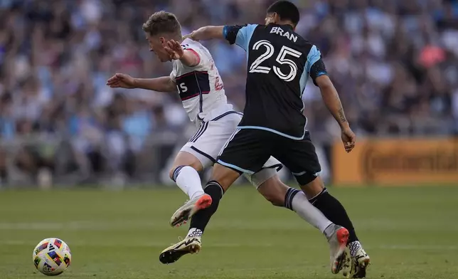 Vancouver Whitecaps midfielder Ryan Gauld, left, and Minnesota United midfielder Alejandro Bran (25) battle for possession during the first half of an MLS soccer match in St. Paul, Minn., Wednesday, July 3, 2024. (AP Photo/Abbie Parr)
